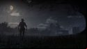 A cowboy standing under the moon at night